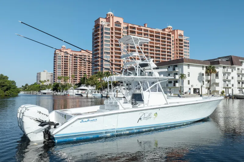 Slide: The Image of 2009 SeaHunter 40 boat docked near waterfront buildings under clear blue sky. - 2