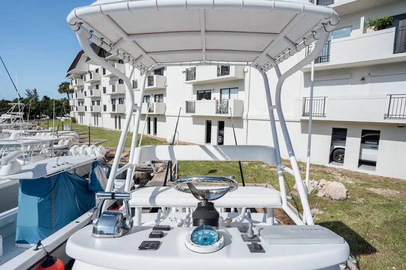Slide: The Image of 2009 SeaHunter 40 boat helm with controls, docked near modern apartments. - 24