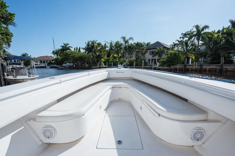 Slide: The Image of 2009 SeaHunter 40 boat with spacious seating, docked near waterfront homes and lush greenery. - 30