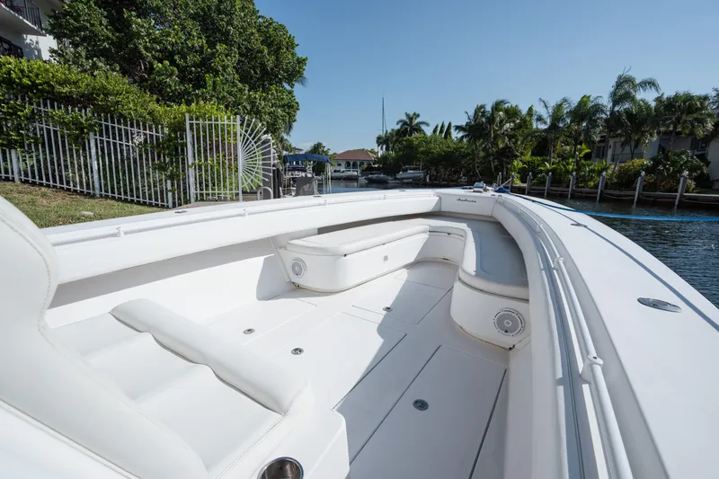 Slide: The Image of 2009 SeaHunter 40 boat with spacious white seating, docked near lush greenery. - 31