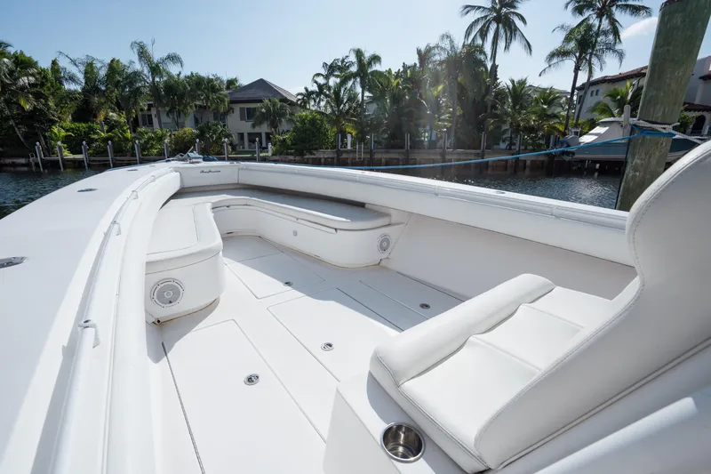 Slide: The Image of Luxurious 2009 SeaHunter 40 boat interior with white seating, docked near palm trees. - 32