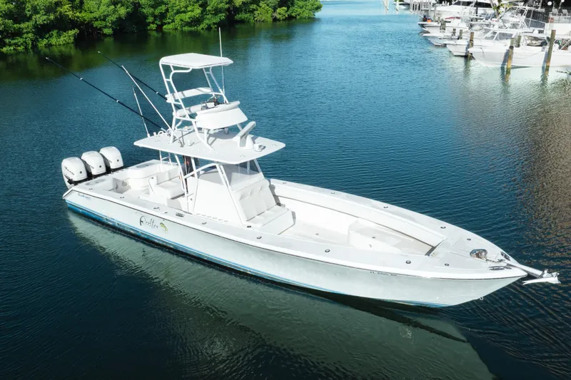 Slide: The Image of 2009 SeaHunter 40 boat with triple engines on calm water, surrounded by greenery. - 4