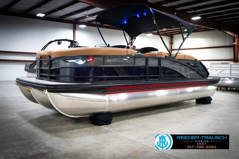 Slide: The Image of 2026 Bennington 22 MSB pontoon boat in showroom with canopy and sleek design. - 2