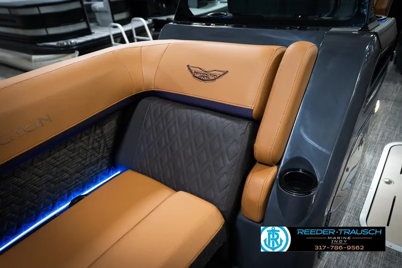 Slide: The Image of 2026 Bennington 22 MSB boat interior with tan leather seating and blue LED lighting. - 22