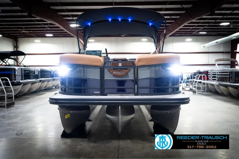Slide: The Image of 2026 Bennington 22 MSB pontoon boat in showroom with bright headlights. - 3