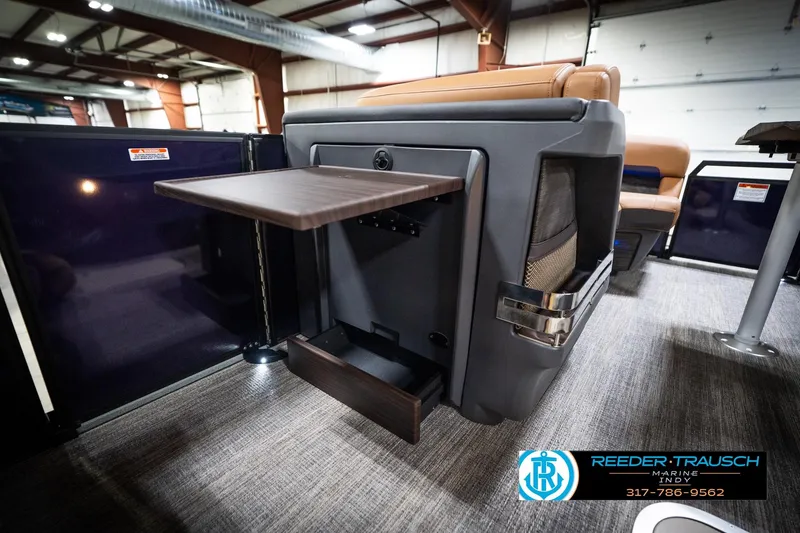 Slide: The Image of 2026 Bennington 22 MSB boat interior with foldable table and seating in showroom. - 32