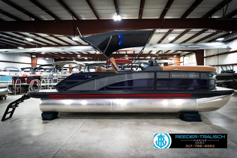 Slide: The Image of 2026 Bennington 22 MSB pontoon boat displayed indoors at Reeder-Trausch Marine showroom. - 5