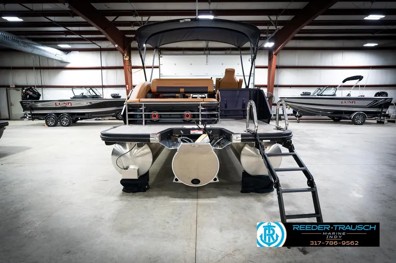 Slide: The Image of 2026 Bennington 22 MSB pontoon boat in showroom with ladder and seating. - 7