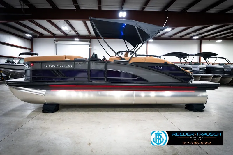 Slide: The Image of 2026 Bennington 22 MSB pontoon boat in showroom with canopy and sleek design. - 9