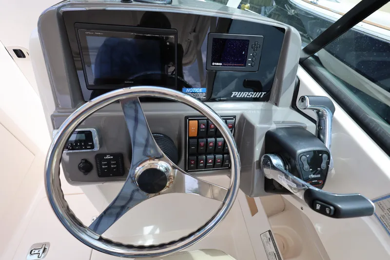 Slide: The Image of 2017 Pursuit DC 265 Dual Console boat dashboard with steering wheel and control panel. - 13