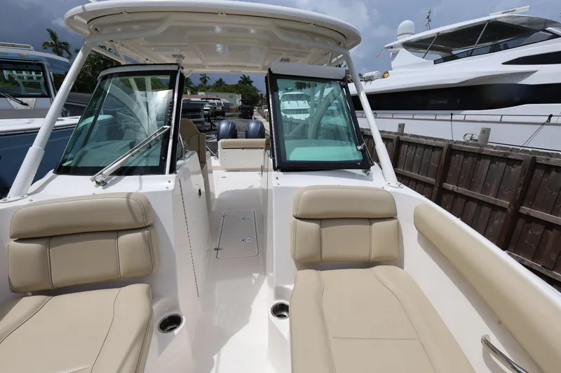 Slide: The Image of 2017 Pursuit DC 265 Dual Console boat with beige seating and open deck. - 17