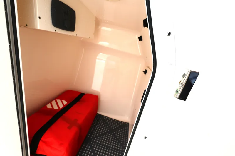 Slide: The Image of 2017 Pursuit DC 265 Dual Console storage compartment with red safety bag. - 19