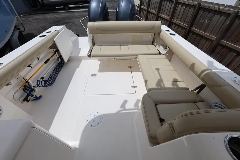 Slide: The Image of 2017 Pursuit DC 265 Dual Console boat interior with beige seating and storage compartments. - 23