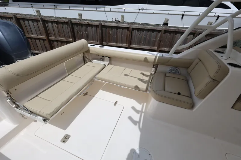 Slide: The Image of 2017 Pursuit DC 265 Dual Console boat interior with beige seating and spacious layout. - 24