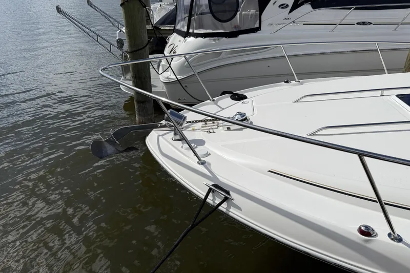 Slide: The Image of 2001 Sea Ray 310 Sundancer docked, showcasing sleek white design and stainless steel railings. - 10