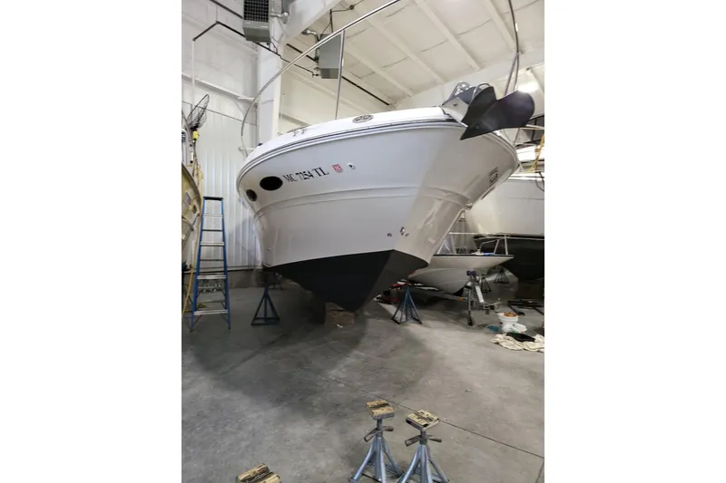 Slide: The Image of 2001 Sea Ray 310 Sundancer boat in indoor storage, elevated on stands. - 12