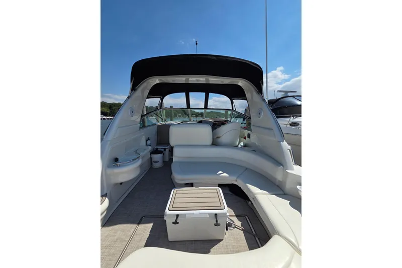 Slide: The Image of 2001 Sea Ray 310 Sundancer boat interior with seating and table under clear blue sky. - 23