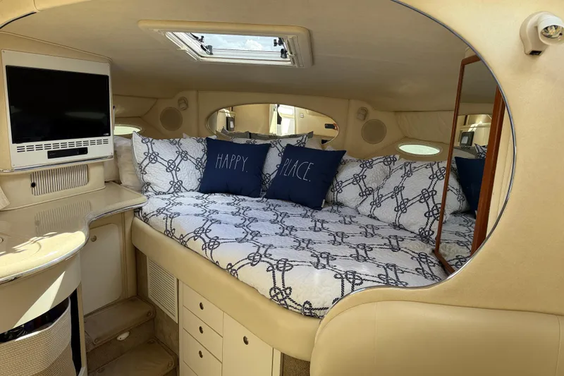 Slide: The Image of 2001 Sea Ray 310 Sundancer cabin interior with cozy bed and TV. - 27