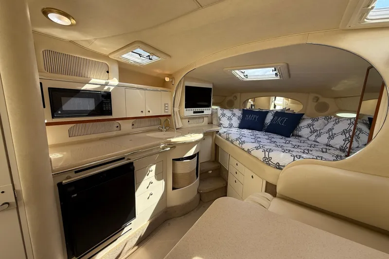 Slide: The Image of Interior of 2001 Sea Ray 310 Sundancer yacht with kitchenette and cozy seating area. - 28