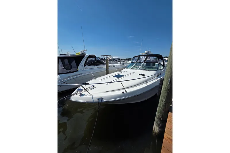 Slide: The Image of 2001 Sea Ray 310 Sundancer docked at marina under clear blue sky. - 3