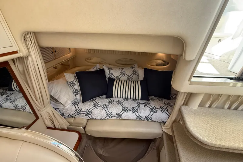 Slide: The Image of Cozy cabin interior of 2001 Sea Ray 310 Sundancer with patterned bedding and cushions. - 31