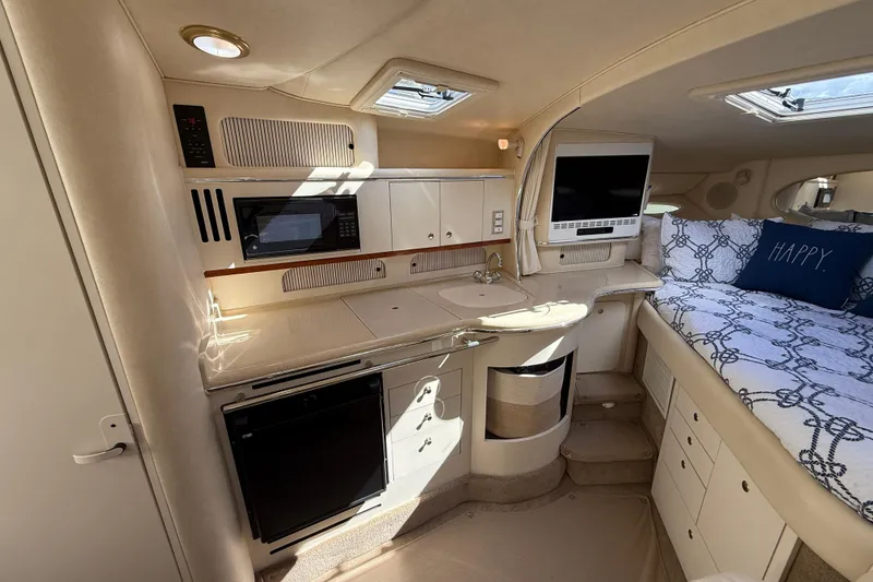 Slide: The Image of 2001 Sea Ray 310 Sundancer interior with kitchenette, bed, and entertainment area. - 32