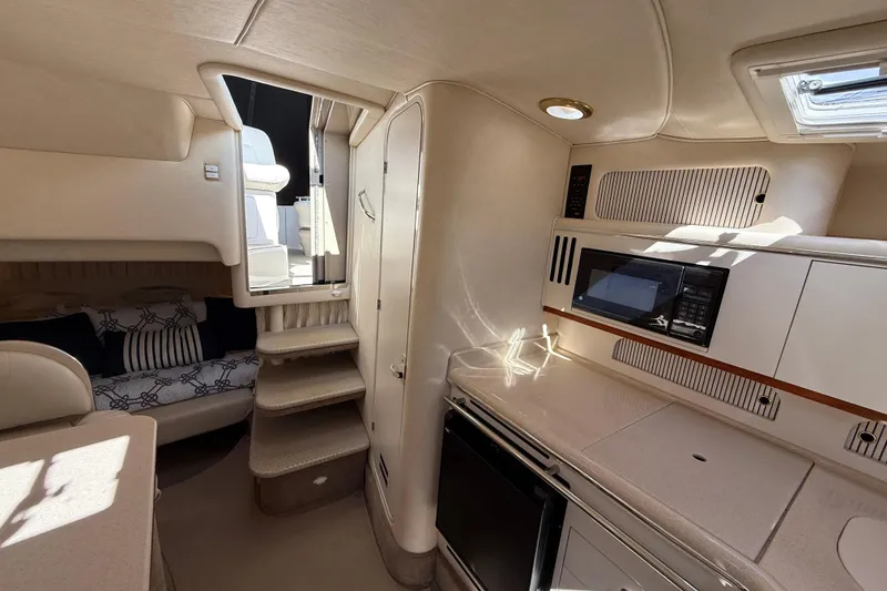 Slide: The Image of Interior of 2001 Sea Ray 310 Sundancer yacht with kitchenette and cozy seating area. - 39