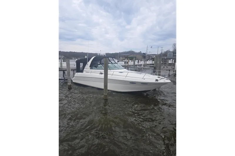 Slide: The Image of 2001 Sea Ray 310 Sundancer boat docked at a marina under cloudy skies. - 4