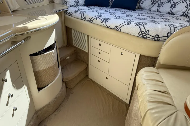 Slide: The Image of Interior of 2001 Sea Ray 310 Sundancer with beige seating and storage cabinets. - 47