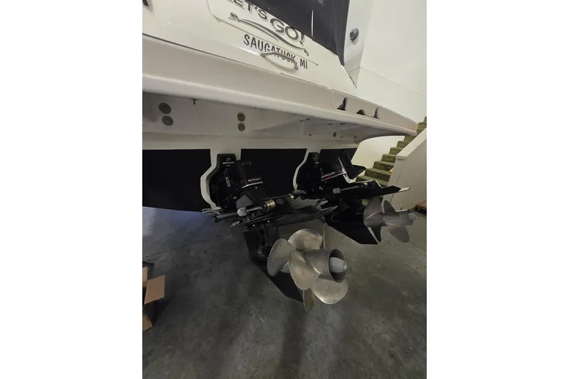 Slide: The Image of 2001 Sea Ray 310 Sundancer boat stern with dual propellers in a garage setting. - 54