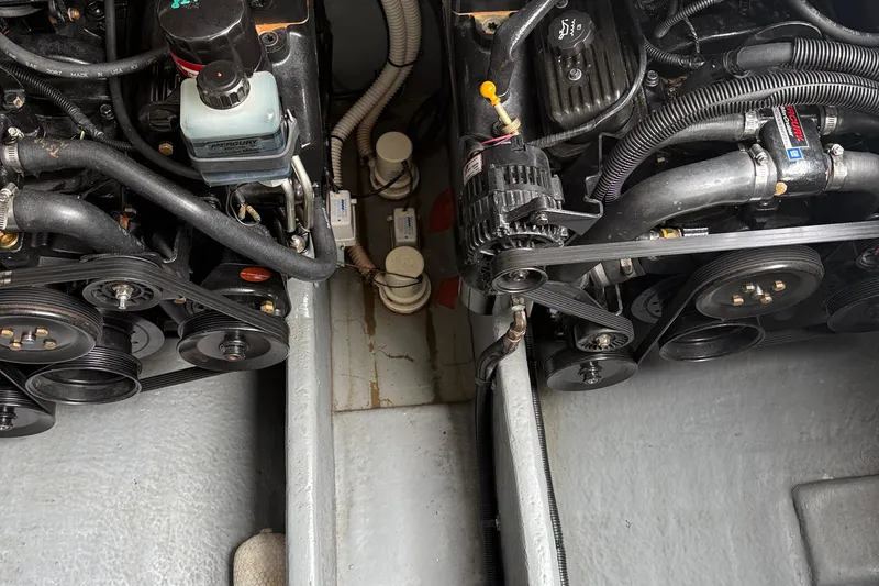 Slide: The Image of Engine compartment of a 2001 Sea Ray 310 Sundancer boat, showing dual engines and belts. - 57