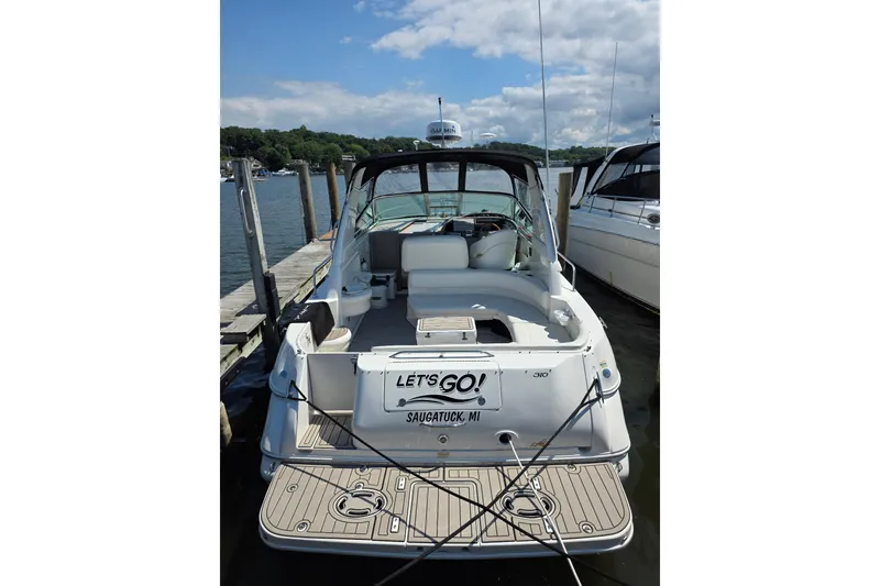 Slide: The Image of 2001 Sea Ray 310 Sundancer docked at Saugatuck, MI, under a clear blue sky. - 6