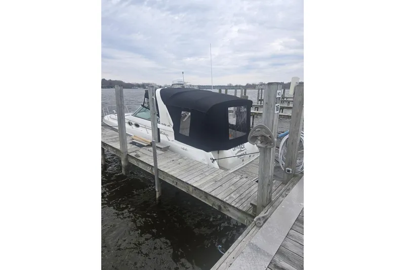 Slide: The Image of 2001 Sea Ray 310 Sundancer docked with black canopy on a cloudy day. - 9