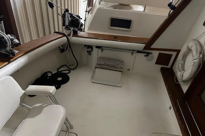 Slide: The Image of 1989 Egg Harbor 37 Convertible boat interior with fishing equipment and seating. - 10