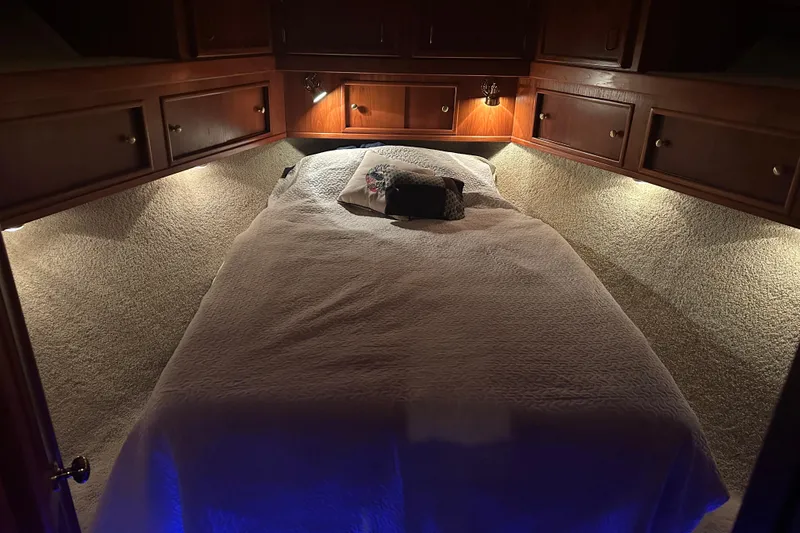 Slide: The Image of Cozy bedroom in 1989 Egg Harbor 37 Convertible yacht with warm lighting and wood cabinetry. - 16