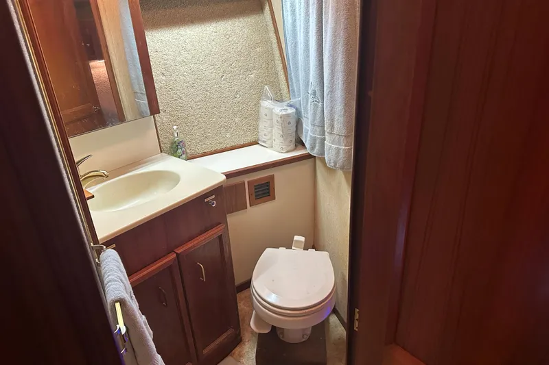 Slide: The Image of 1989 Egg Harbor 37 Convertible yacht bathroom with sink, toilet, and wooden cabinetry. - 21