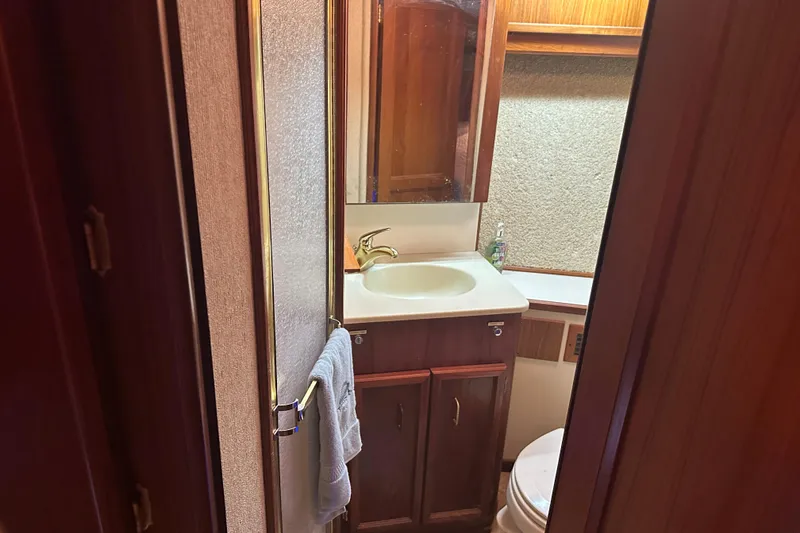 Slide: The Image of Bathroom interior of 1989 Egg Harbor 37 Convertible yacht, featuring sink and wooden cabinetry. - 22
