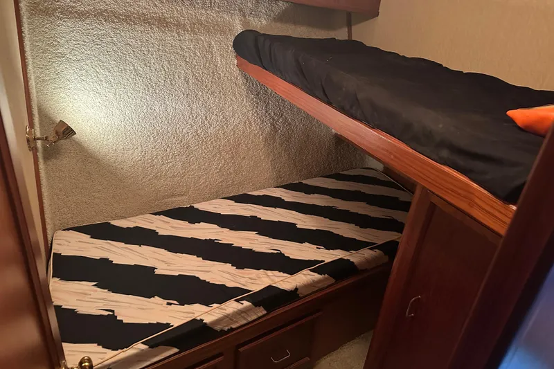 Slide: The Image of 1989 Egg Harbor 37 Convertible cabin with bunk beds and wood paneling. - 23