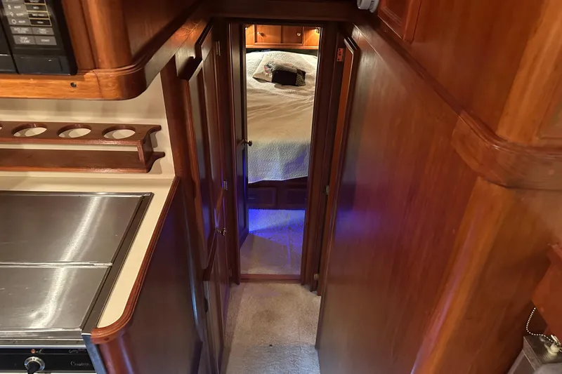 Slide: The Image of Interior of 1989 Egg Harbor 37 Convertible yacht, featuring wood paneling and cozy bedroom. - 24