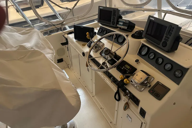 Slide: The Image of Cockpit of 1989 Egg Harbor 37 Convertible with steering wheel and navigation instruments. - 32
