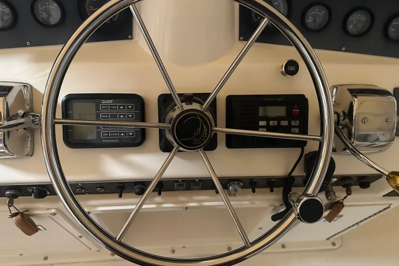 Slide: The Image of Steering wheel and controls of a 1989 Egg Harbor 37 Convertible boat. - 37