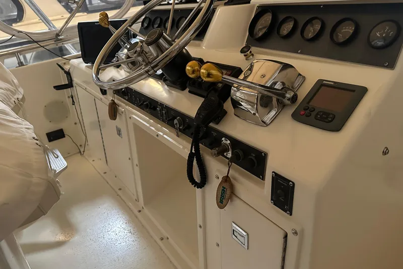 Slide: The Image of 1989 Egg Harbor 37 Convertible boat cockpit with steering wheel and control panel. - 38