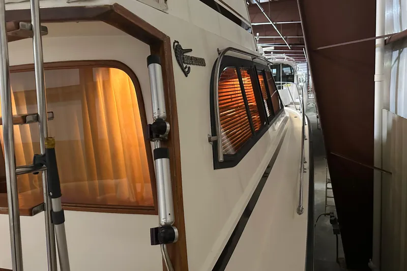 Slide: The Image of 1989 Egg Harbor 37 Convertible yacht in storage, side view with orange-lit windows. - 46