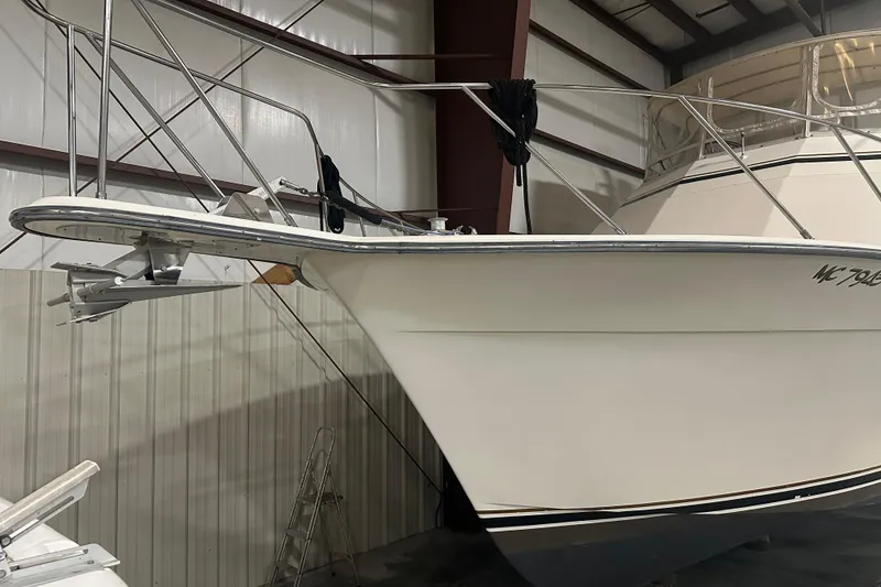 Slide: The Image of 1989 Egg Harbor 37 Convertible boat in indoor storage, showcasing bow and anchor. - 5