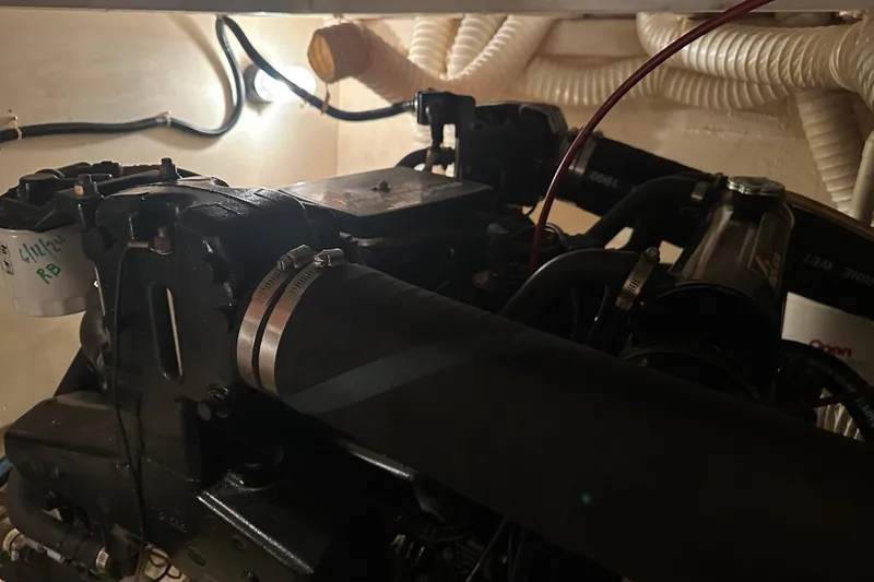 Slide: The Image of Engine compartment of 1989 Egg Harbor 37 Convertible boat, showcasing mechanical components and hoses. - 55