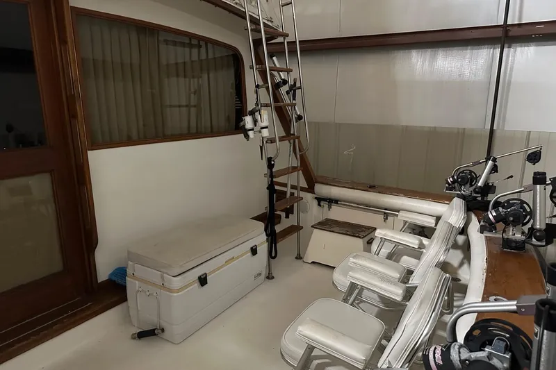 Slide: The Image of 1989 Egg Harbor 37 Convertible boat interior with fishing gear and seating area. - 6