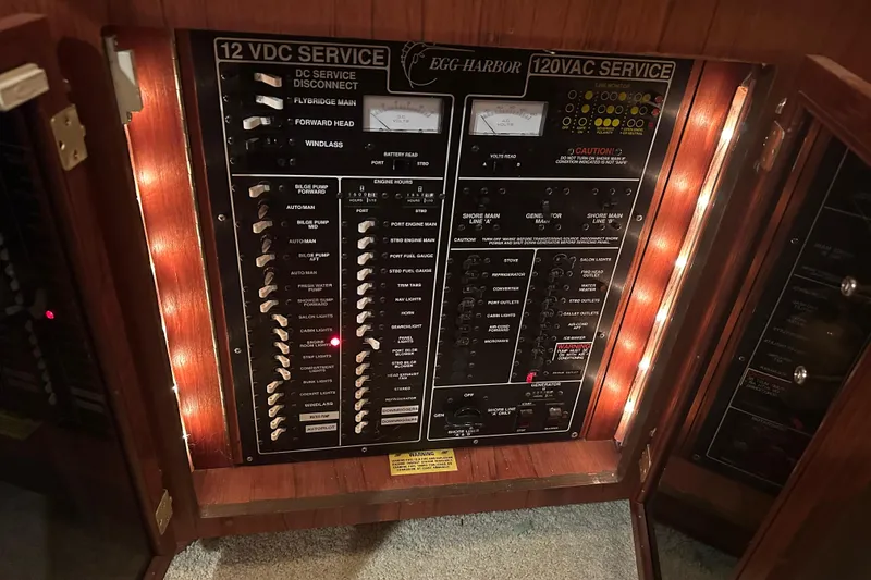 Slide: The Image of Electrical panel of 1989 Egg Harbor 37 Convertible boat, featuring 12VDC and 120VAC services. - 66