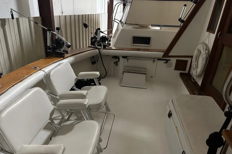 Slide: The Image of 1989 Egg Harbor 37 Convertible boat interior with fishing equipment and seating. - 7