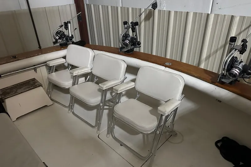 Slide: The Image of 1989 Egg Harbor 37 Convertible boat interior with fishing chairs and rods. - 9