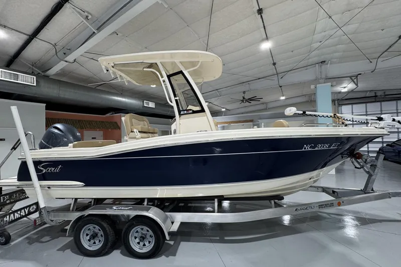 Slide: The Image of 2023 Scout 215 XSF boat on trailer in indoor showroom. - 0